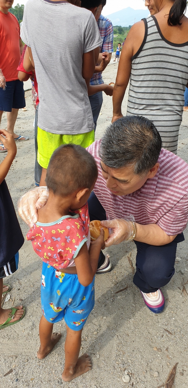 필리핀 엥헬레스시 외곽 하오빌 빈민촌을 들려 어린이들에게 빵을 나눠 주고 있다.