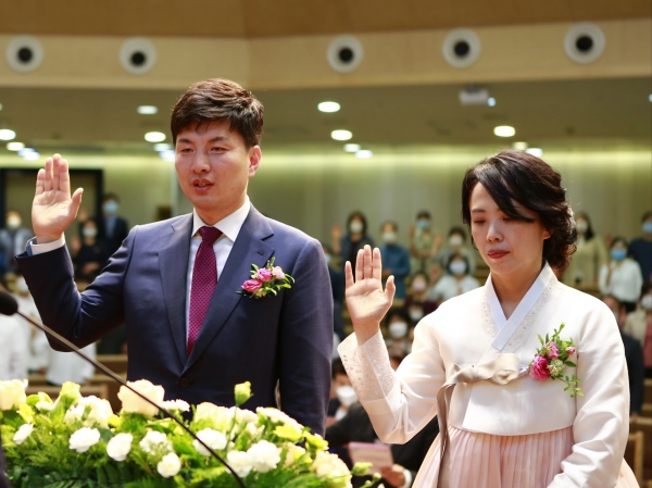 부산 온누리교회에 취임하는 박성수 목사가 아내  최은혜 사모와 함께 손을 들고 취임문답을 하고 있다.