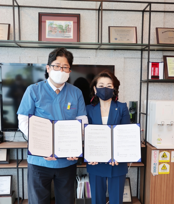 정동수 원장(좌)과 김희매 대표가 협약서에 서명 후 포즈를 취했다.