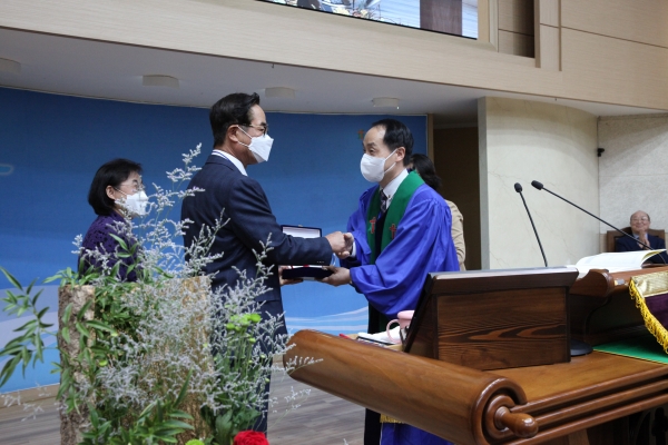 노회장 박남규 목사로부터 추대패를 받고 있다.