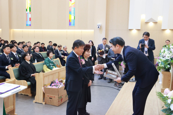 안효찬 위임목사로부터 추대패를 받고 있다.
